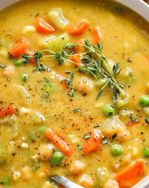 Bowl of comforting one-pot creamy vegetable soup with fresh vegetables