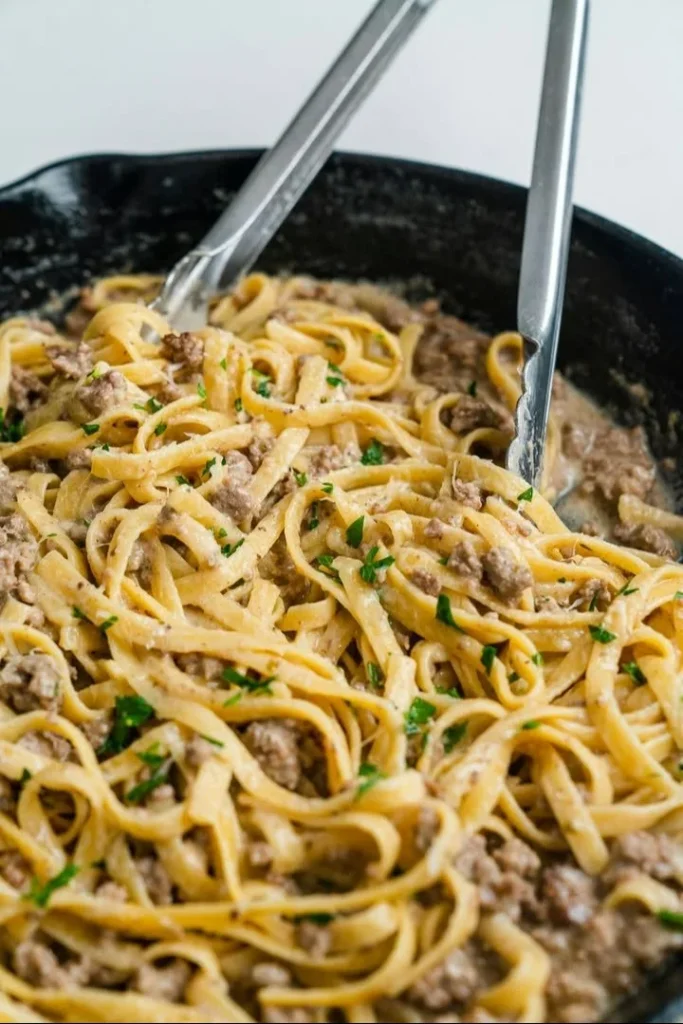 Delicious creamy pasta dish topped with fresh herbs and grated cheese.