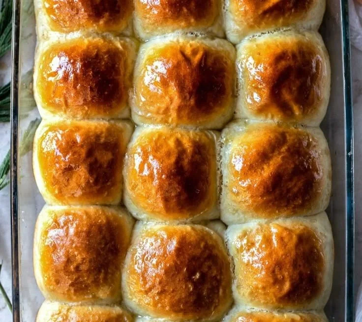 Freshly baked gluten-free dinner rolls on a rustic wooden table.