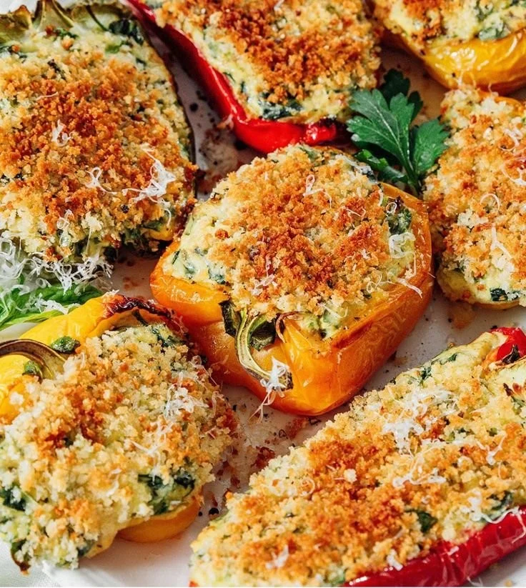 Herby ricotta stuffed peppers fresh from the oven, garnished with herbs.