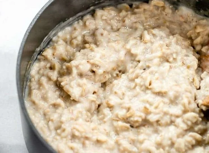 Bowl of freshly made oatmeal topped with fruits and nuts