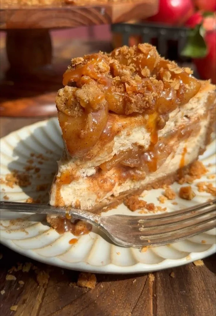 Salted Caramel Apple Pie Cheesecake topped with caramel sauce and apple slices