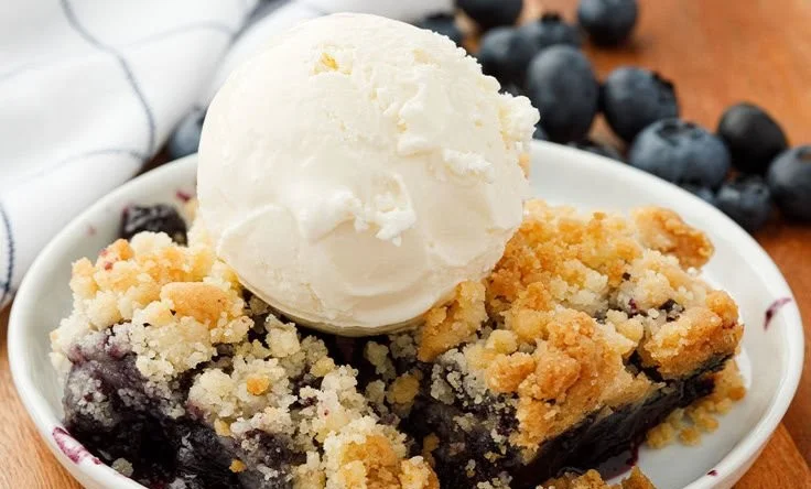 A delicious blueberry crisp dessert with a golden oat topping and fresh blueberries.