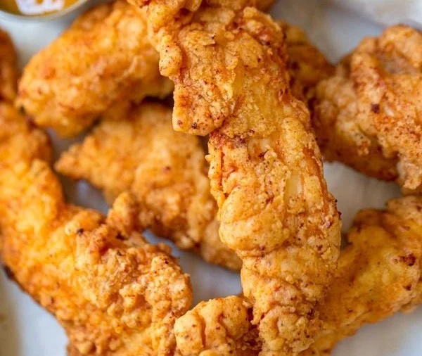 Plate of crispy chicken tenders with dipping sauce