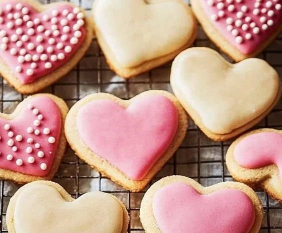 Heart-shaped sugar cookies on a decorative plate, perfect for any occasion.