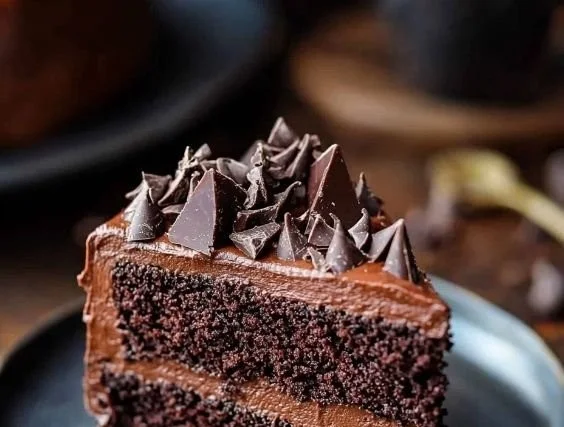 Moist chocolate cake with rich frosting on a rustic wooden table