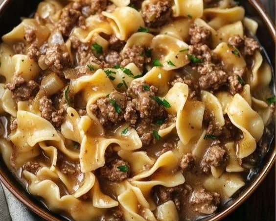 A bowl of easy beef and noodles served with herbs and vegetables.