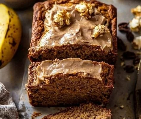 Freshly baked Maple Banana Bread sliced and served on a wooden board.
