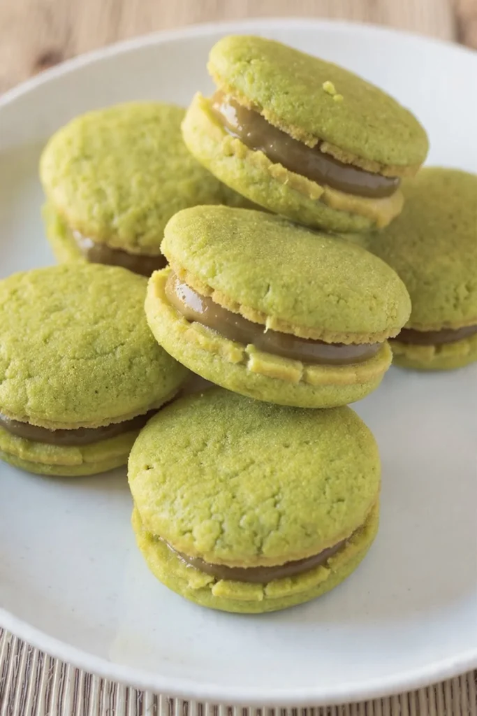 Delicious pandan palm sugar sandwich cookies displayed on a plate.
