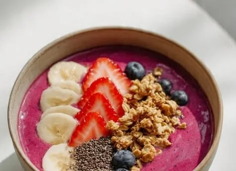 Colorful smoothie bowl topped with granola and fresh fruits