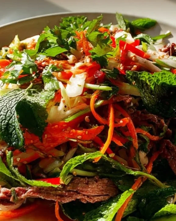 A colorful bowl of Vietnamese Beef Salad with fresh herbs and sliced beef.