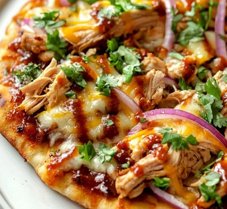 BBQ chicken flatbread topped with fresh ingredients and drizzled with sauce