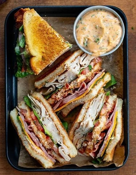 Delicious Cowboy Club Sandwich with layers of meat, lettuce, and tomato.