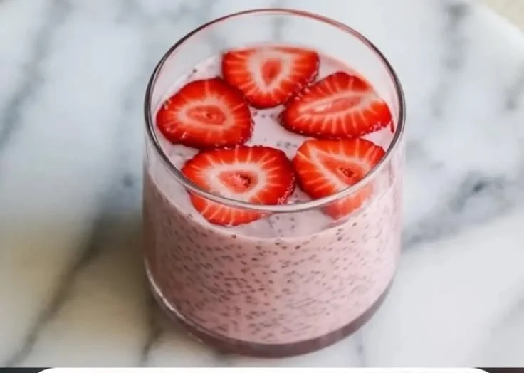 Bowl of strawberry chia seed pudding topped with fresh strawberries and mint