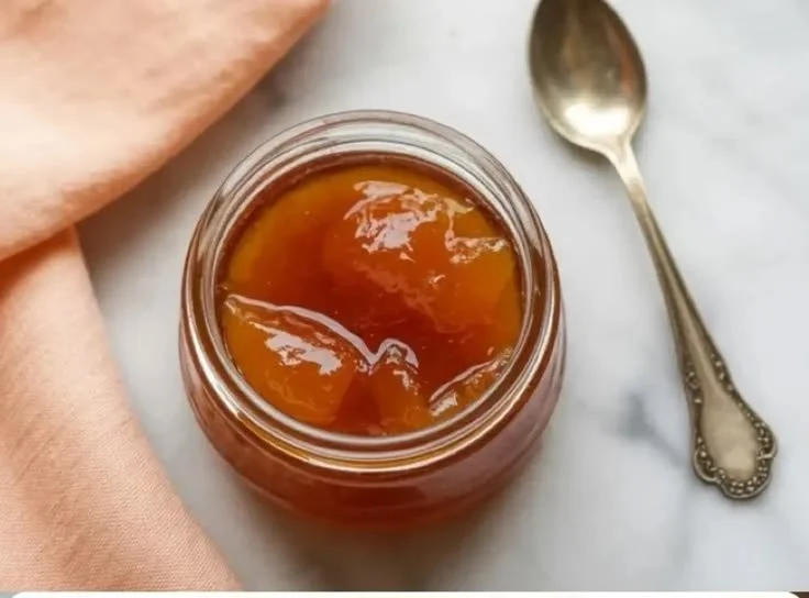Homemade easy apricot jam in a jar with fresh apricots