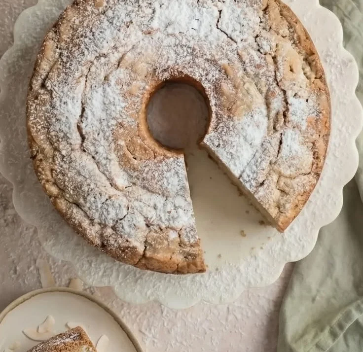 Slice of Easy Coconut Cream Cheese Pound Cake on a plate garnished with coconut flakes.