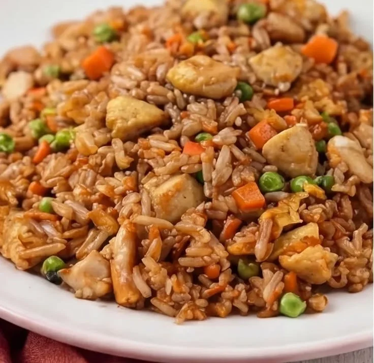 Bowl of homemade chicken fried rice with vegetables and chicken pieces