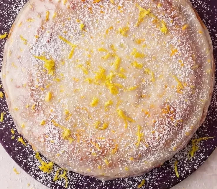 Slice of limoncello ricotta cake topped with lemon zest and mint