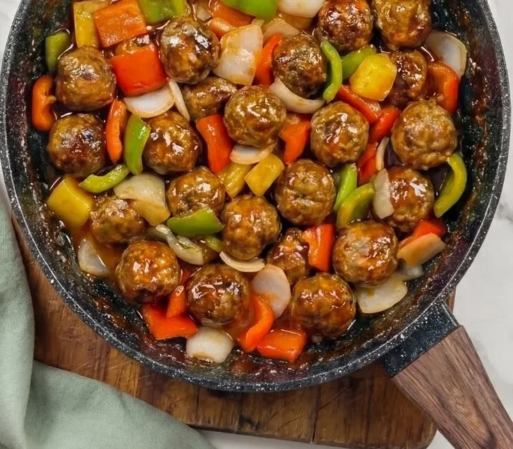 Plate of sweet and sour meatballs garnished with green onions
