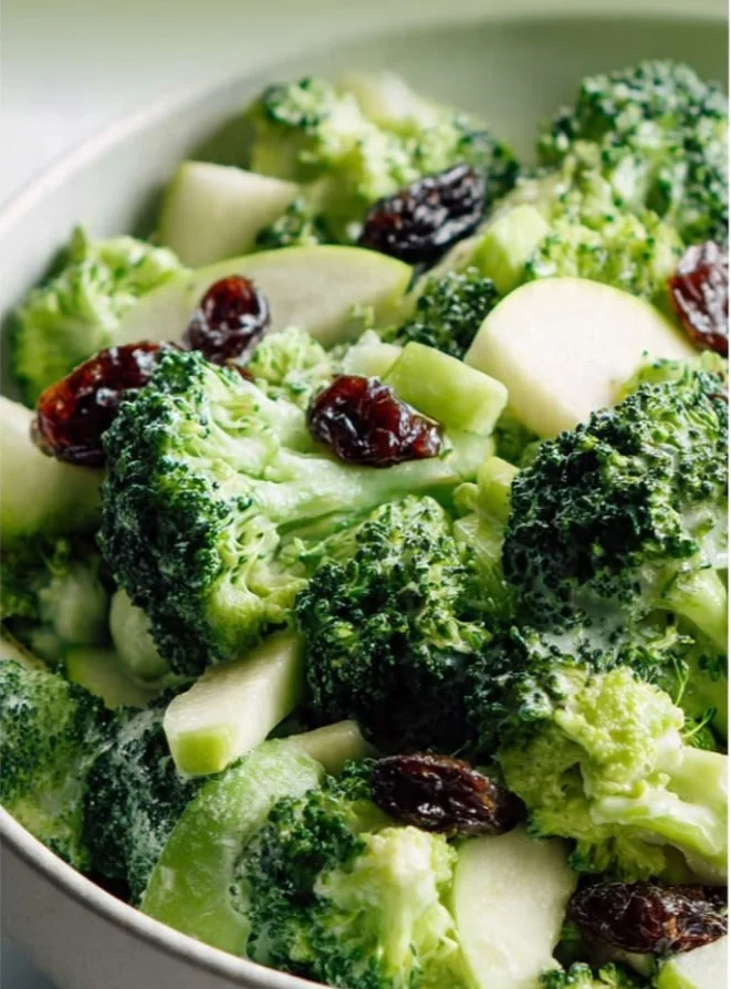 Broccoli salad with dried cherries, nuts, and a light dressing on a plate