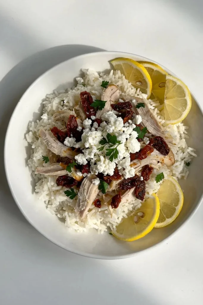 Viral shaken rotisserie chicken served with rice, lemon, feta, and sun-dried tomatoes.